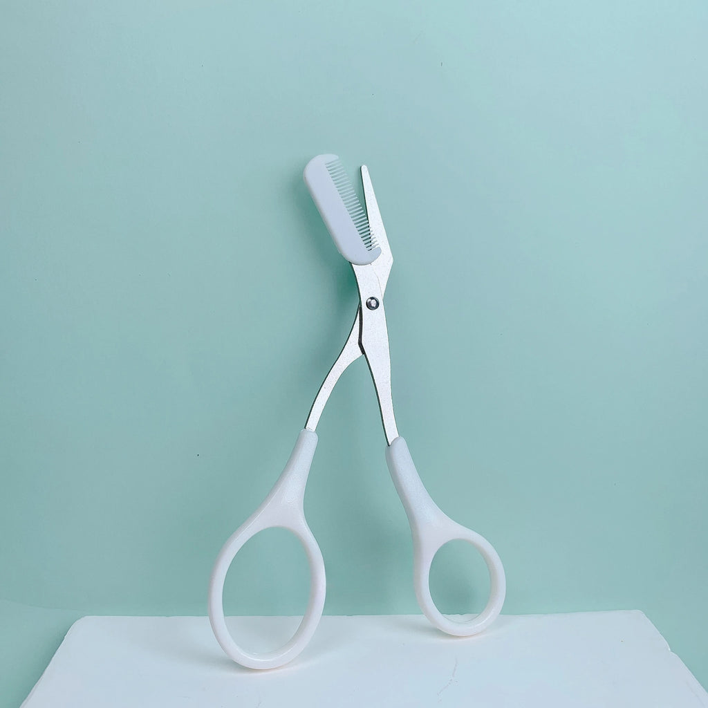 Pink eyebrow trimming scissors with built-in comb